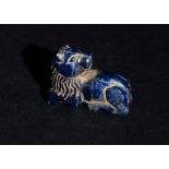 A GREEK OR ROMAN LAPIS LAZULI RECLINED LION AMULET, CIRCA 5TH CENTURY OR LATER