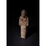 AN EGYPTIAN CARVED STONE SHABTI, LATE PERIOD 1550-332 BC