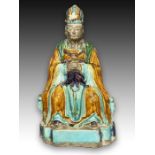 A CHINESE SANCAI GLAZED STONEWARE FIGURE OF A SEATED DIGNITARY, MING DYNASTY (1368-1644)