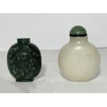 A CHINESE CARVED SPINACH JADE SNUFF BOTTLE AND A WHITE LIDDED SNUFF BOTTLE
