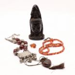 A CHINESE CHERRY AMBER HEAD OF A GUANYIN AND ASSORTMENT OF AMBER BEADS AND FIGURES