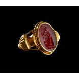 A GREEK GOLD AND CARNELIAN RING OF SEATED ATHENA HOLDING A SPEAR & SHIELD