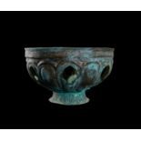 A GREEK PIERCED BRONZE FOOTED BASIN, CIRCA 5TH CENTURY OR LATER