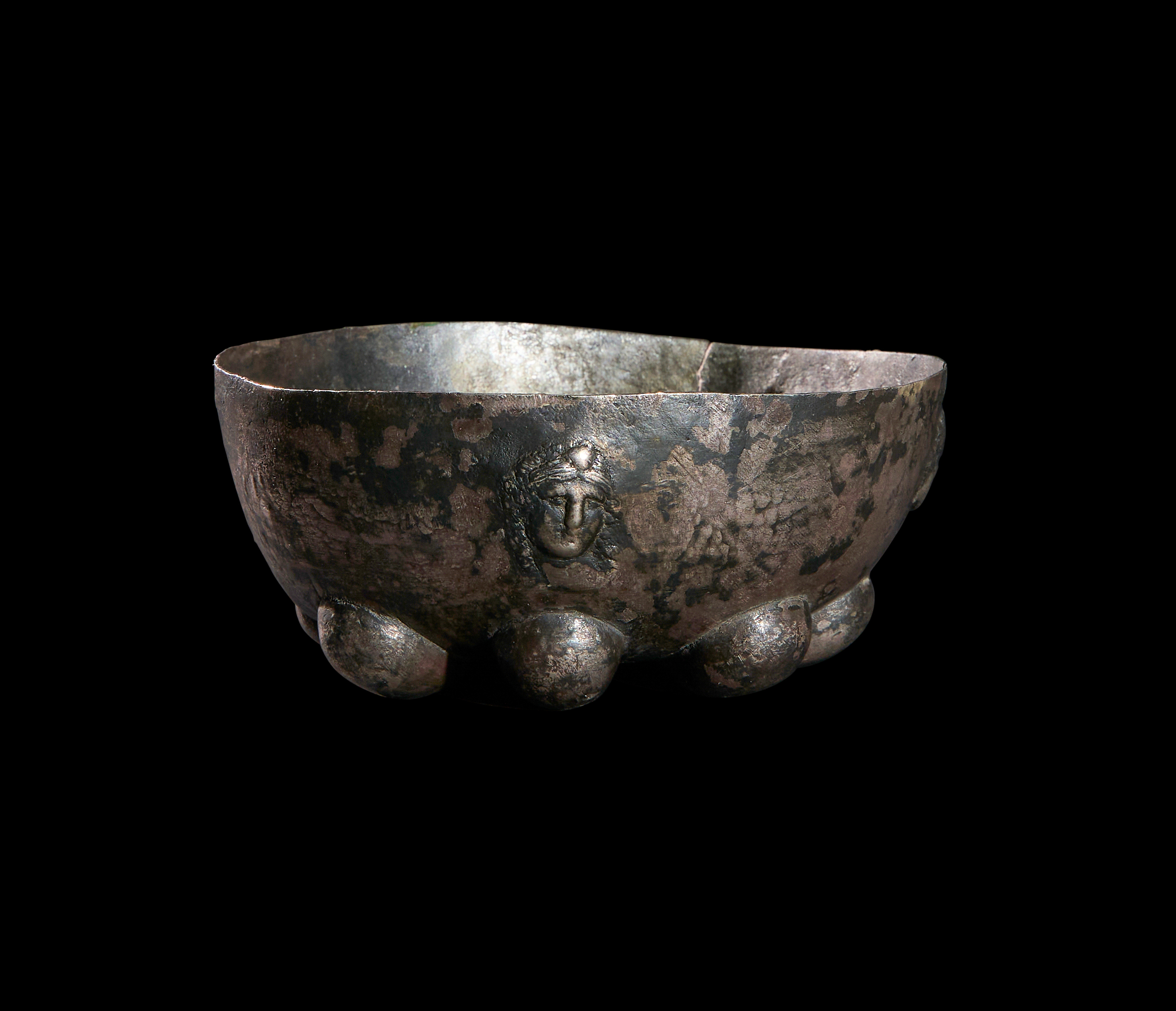 A SILVER HELLENISTIC RIBBED GEOMETRICAL BOWL WITH FACES CIRCA 3RD-2ND CENTURY B.C.
