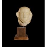 A SOUTH ARABIAN ALABASTER HEAD WITH INSCRIPTION IN SABAEAN SCRIPT, CIRCA 1ST MILLENNIUM B.C.