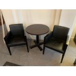 A pair of upholstered black chairs with leather upholstery and wooden frame with round pedestal