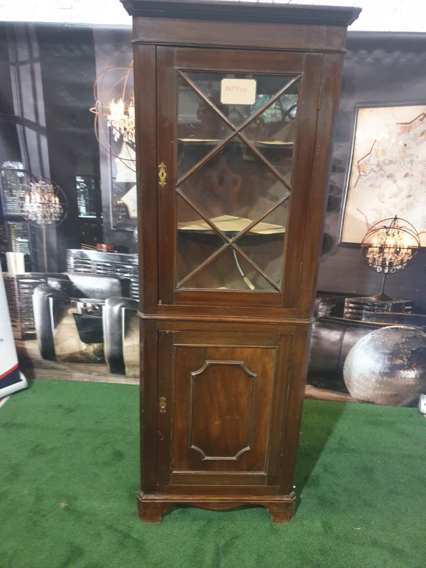 A mahogany standing corner cupboard in George III style. The moulded cornice above a single glazed