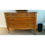 A Georgian style three drawer chest of drawers with serpentine shaped front with sabre front legs