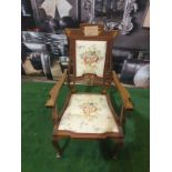 A mahogany and marquetry armchair.The flower and leaf-inlaid shaped toprail above an oblong padded