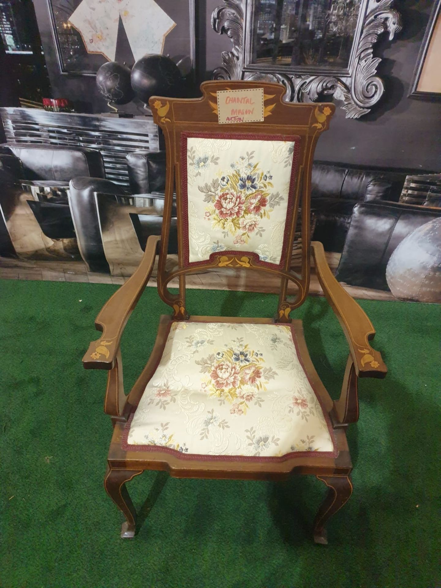 A mahogany and marquetry armchair.The flower and leaf-inlaid shaped toprail above an oblong padded
