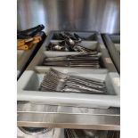 A large quantity of stainless steel cutlery within trays as found