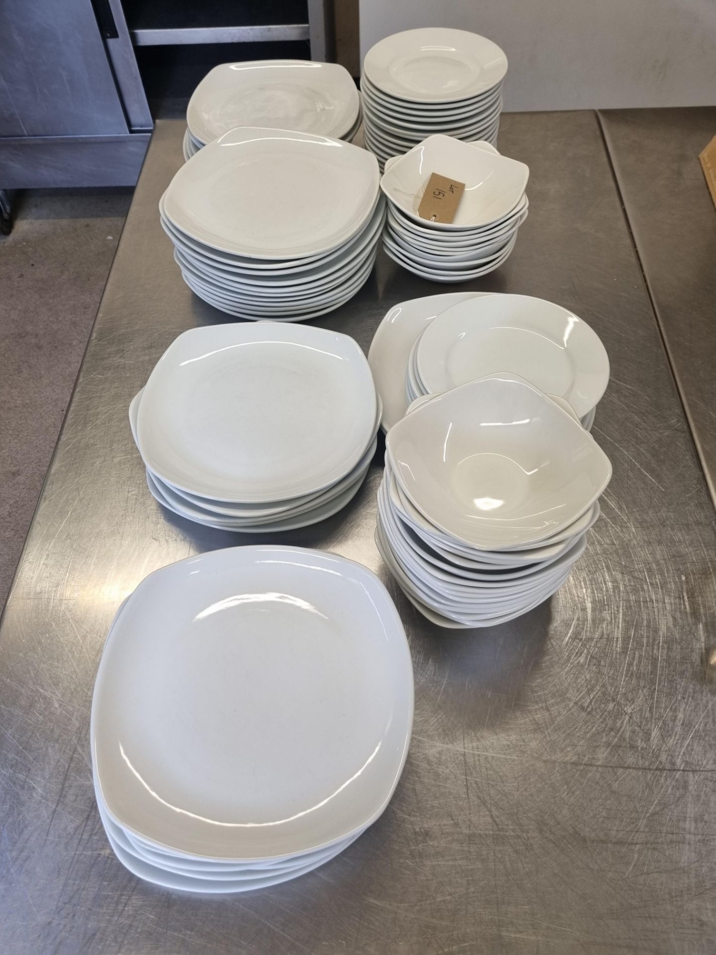 A large selection of white table wear comprising of dinner plates, side plates, bowls etc as found