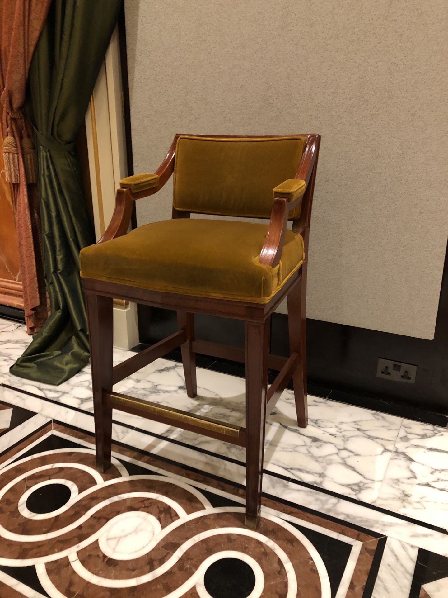 Neoclassic style mahogany tall bar stool, with a aged gold upholstered padded back and seat part
