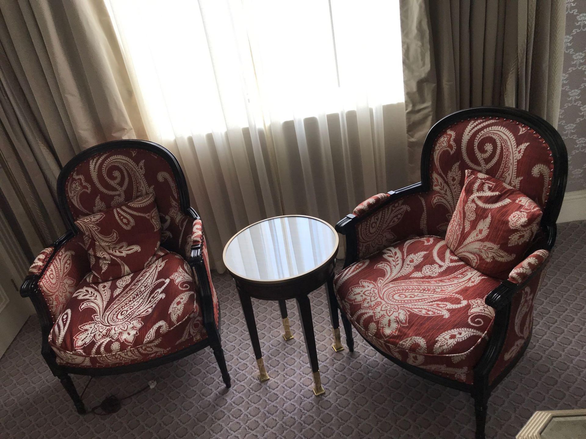 A Pair Of Bergere Chairs Black Wood Frame Upholstered In A Rust Red And Cream Damask Pattern With