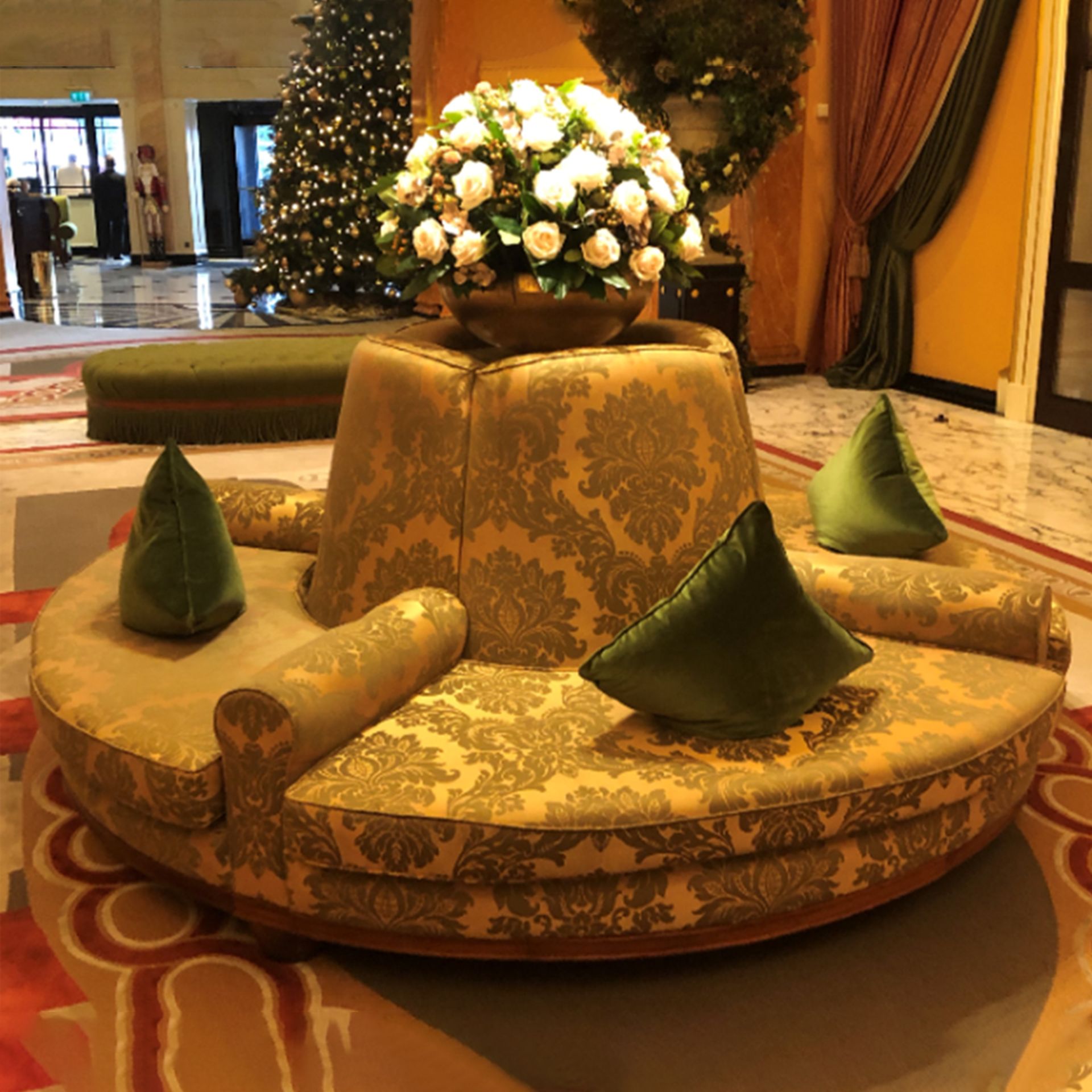 Round Lobby Banquette Sofa on mahogany frame upholstered Pierre Frey tournelle in gold and green