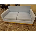 A Blue Upholstered  Plush Fabric Sofa Offering A Decidedly Modern Take On The Classic Chesterfield