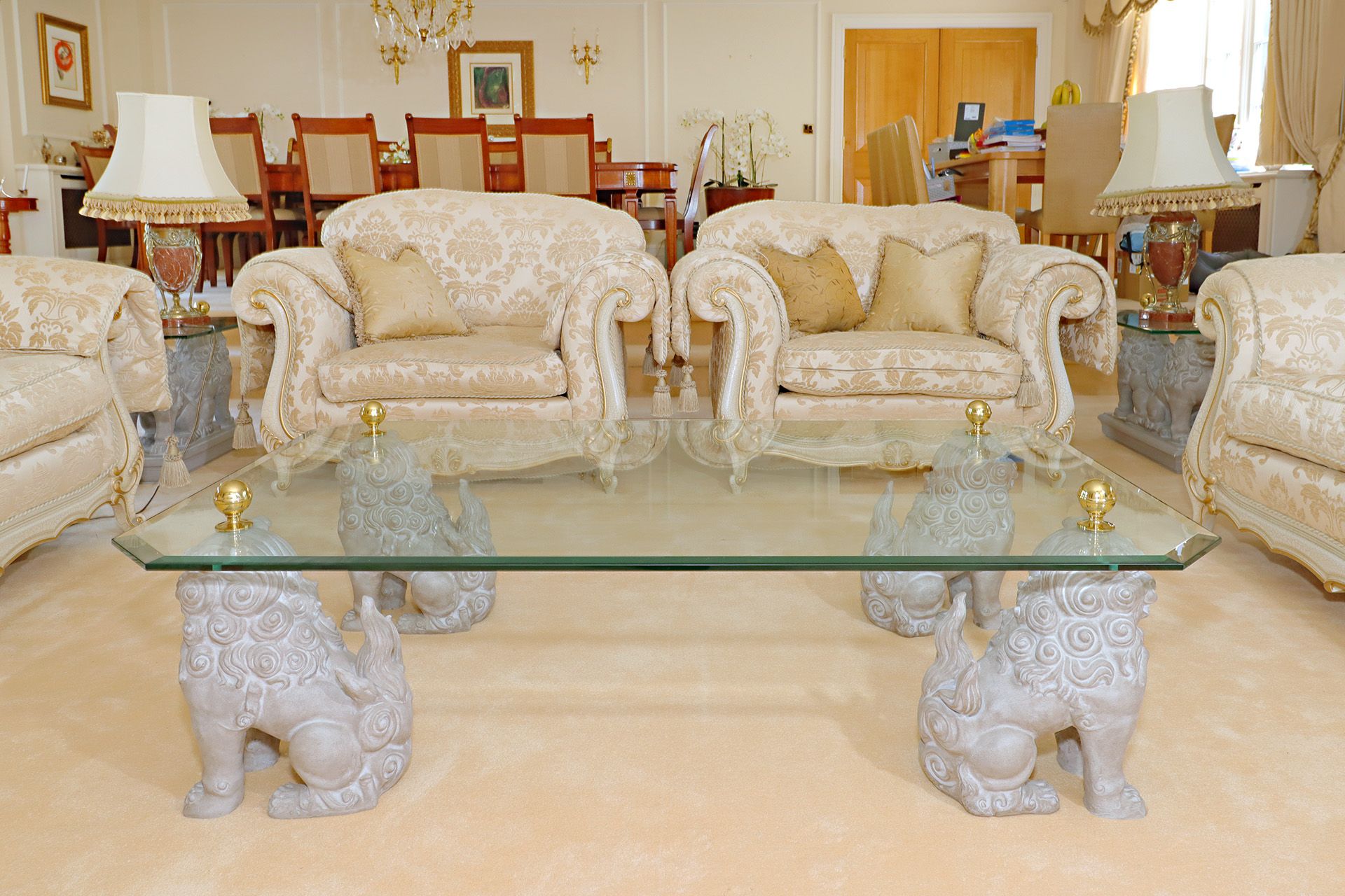 Glass top coffee table supported by a quadrant of guardian lion foo Dog pedestals with brass