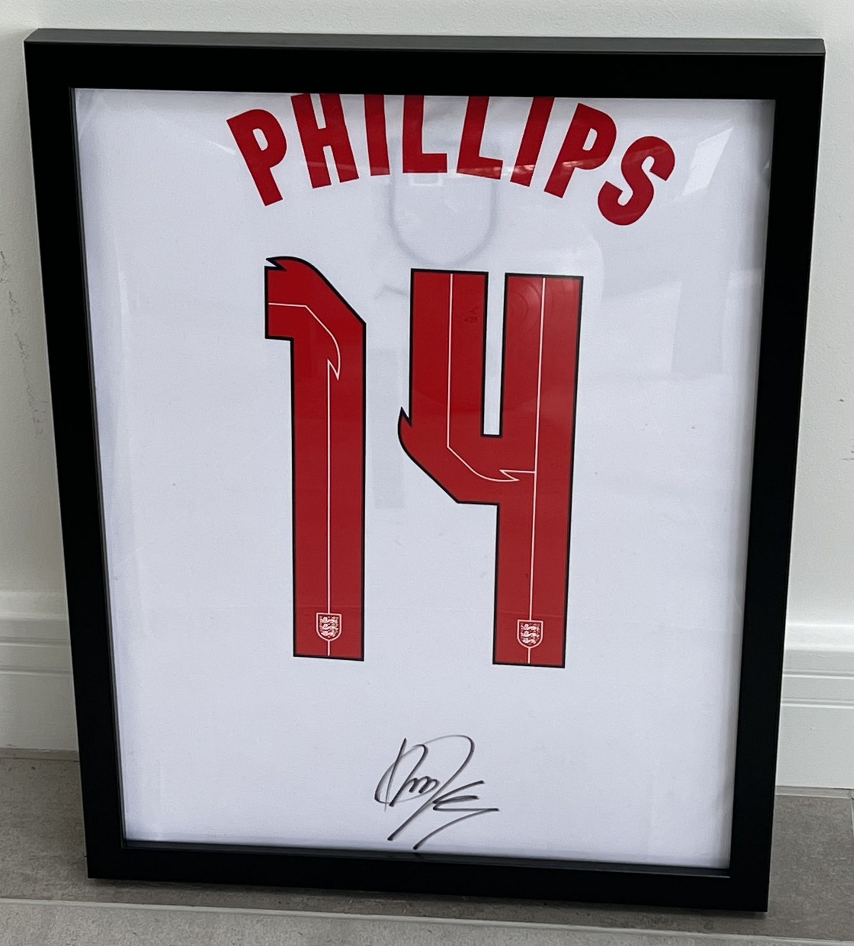 Authentic Kalvin Phillips hand signed England football shirt presentation. The shirt is displayed in