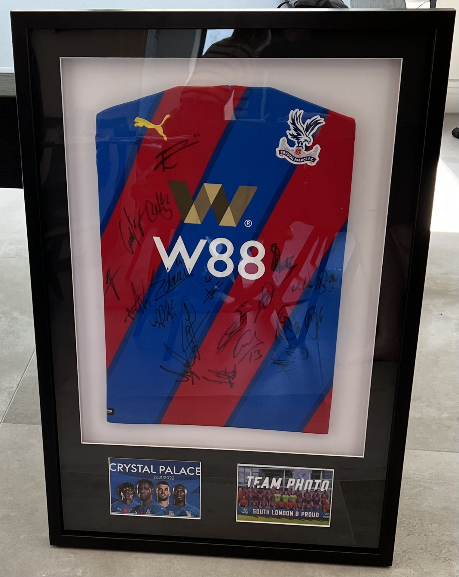 A Crystal Palace FC display, featuring a signed shirt from the 2021/22 season. The shirt is