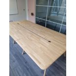 A contemporary hardwood boardroom table mounted on eight scandi form legs with central void for