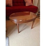 A Regency Style Ovoid Coffee Table Shaped Mahogany Top Raised On Tapered And Turned Fluted Legs With