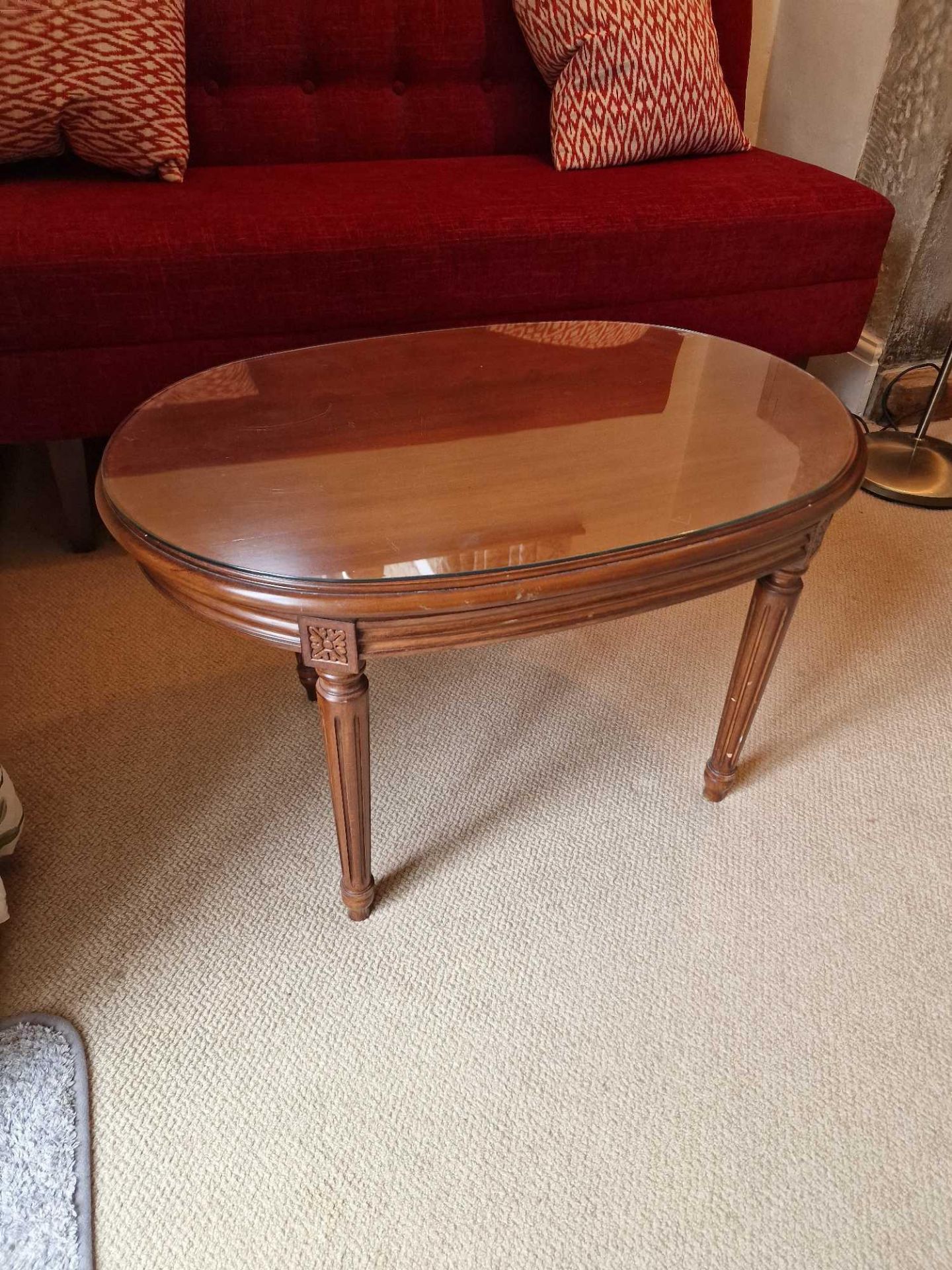 A Regency Style Ovoid Coffee Table Shaped Mahogany Top Raised On Tapered And Turned Fluted Legs With