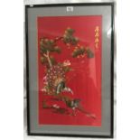 A RED SILK ORIENTAL EMBROIDERY OF BIRDS AND PINE TREE WITH EMBROIDERED SIGNATURE AND STAMP