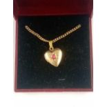 A GOLD PLATED LOCKET WITH RUBY, BOXED