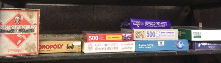 SHELF OF VARIOUS JIGSAW PUZZLES & BOXED MONOPOLY GAME