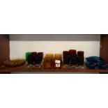 SHELF OF COLOURED GLASSWARE WITH WINE GLASSES, TUMBLERS, NIBBLES, DISHES ETC