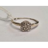 A 9ct WHITE GOLD RING WITH CIRCULAR DIAMOND CLUSTER