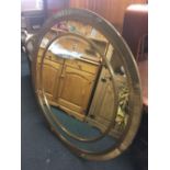 LARGE CIRCULAR GILT FRAMED ORNAMENTAL MIRROR WITH BEVELLED EDGE, 4ft WIDE