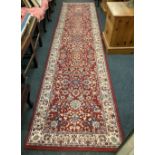 RED GROUND PATTERNED WOOLLEN RUG, 13ft 6'' X 2ft 8'' APPROX