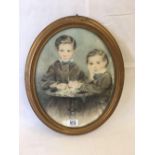 AN OVAL 19THC PASTEL DRAWING. A PORTRAIT OF TWO YOUNG BOYS STOOD BY A SMALL ROUND TABLE, OVAL, 7'' X