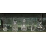 SHELF OF 7 CUT GLASS DECANTERS,