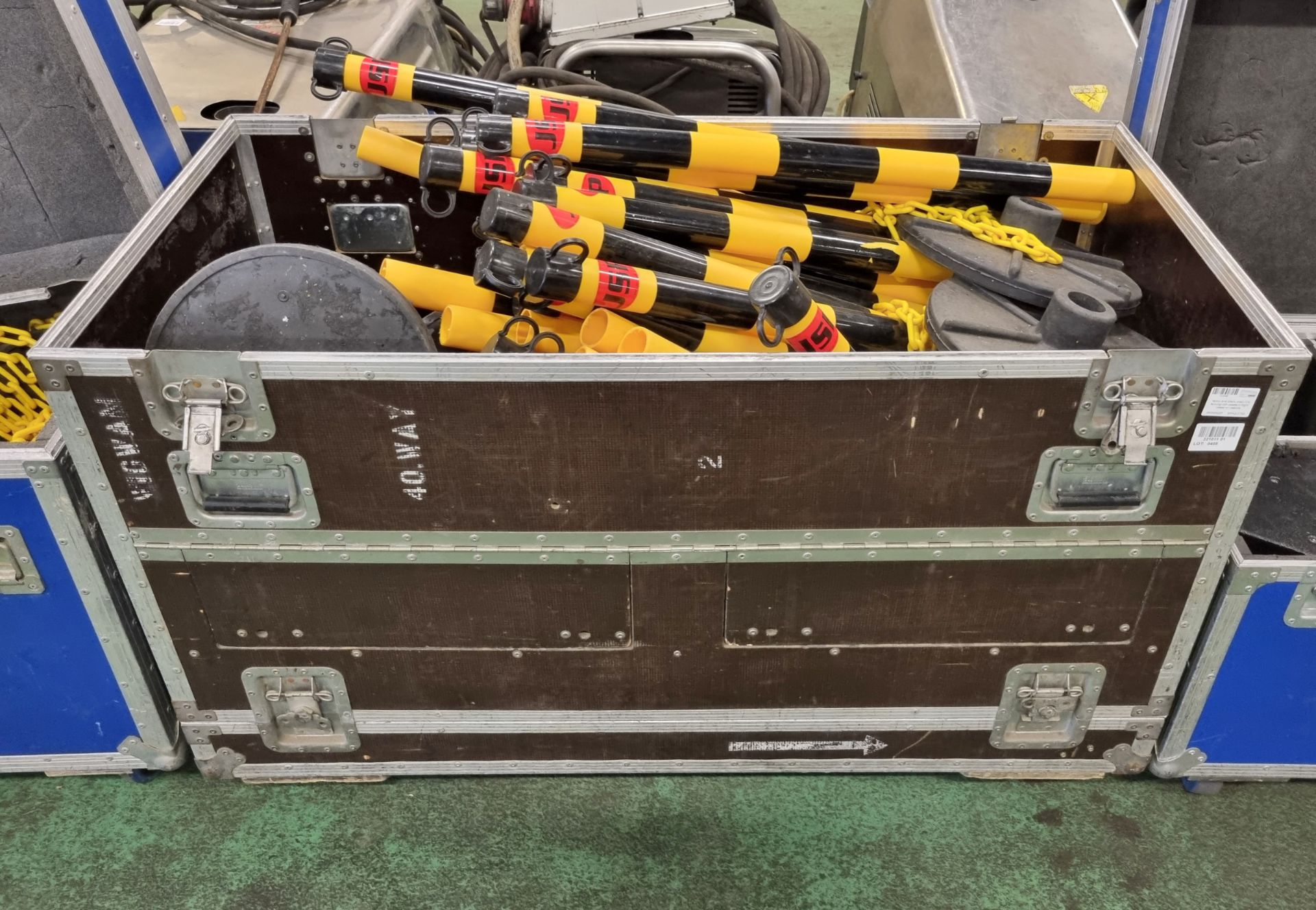 Yellow and black chain link fencing with bases in flight cases on castors