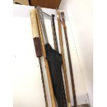 A collection of sticks, umbrellas and golf club, including a stick with leather exterior and