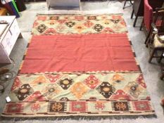 An Oka flatweave rug with raspberry field, with geometric borders to two sides (300cm x 250cm)