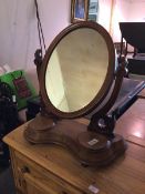 A Victorian mahogany dressing table mirror, the oval mirror on moulded supports, the serpentine base