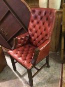 A 1930s/40s library armchair with button back, arms and seat, upholstered in red leatherette style