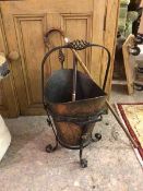 An early 20thc copper coal scuttle on a cast iron frame (60cm x 44cm x 36cm) and cane walking