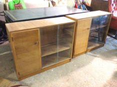 A pair of mid century teak side cabinets, with rectangular tops above single doors enclosing a