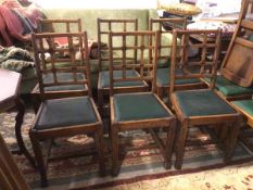 A set of six oak 1930s side chairs, the lattice backs with rosettes above green vinyl seats, on