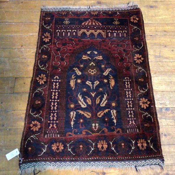 A North West Persian prayer rug with central mirab within a foliate border (110cm x 80cm)