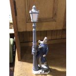 A Spanish Lladro style porcelain figure, The Lamplighter, complete with pole, decorated with