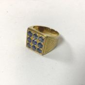 A gentleman's gilt metal ring set nine blue stones set in chequerboard pattern (Y)