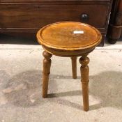 A mahogany stool with dished circular top on three splay turned supports (45cm x 33cm)