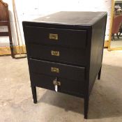 A vintage plywood four drawer filing cabinet with recessed brass handles, on square tapered
