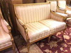 A gilt wood Napoleon III style two seater canope upholstered in striped fabric, on moulded