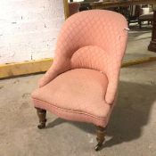 A Victorian nursing chair in later rose coloured upholstery, on turned front supports ending in